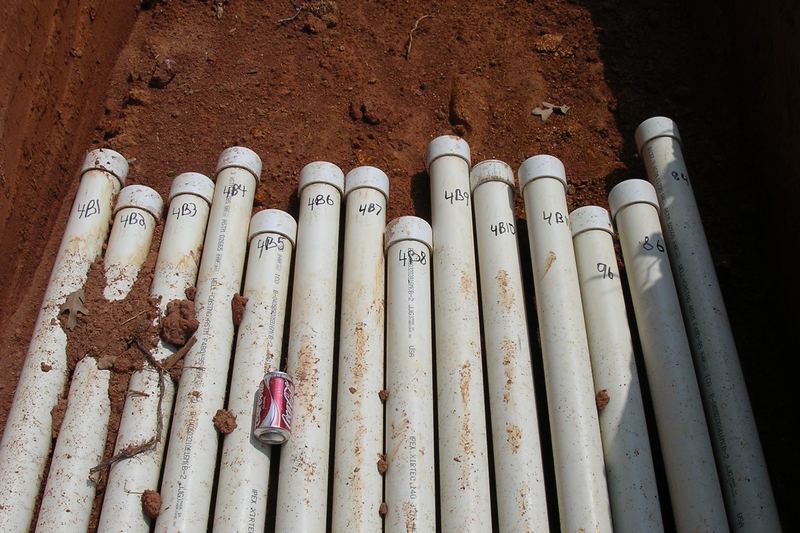 PVC pipes stacked upright in an open trench